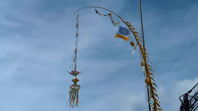Balinese Hindu penjor decorative bamboo pole with offerings to ancestral spirits on Galungan festival in Bali Indonesia