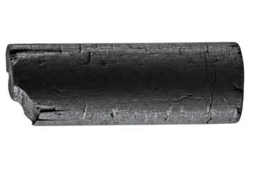 Cylindrical piece of black natural wood charcoal for fuel isolated on a transparent background