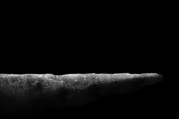 Stone podium on dark black background..