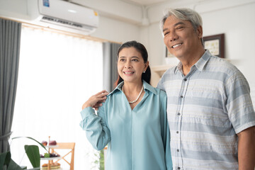 Obraz premium Asian senior man embracing wife and talking together. Retired couple spending time in the morning at home. Healthy and life insurance concept
