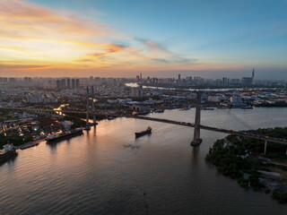 Dusk view of Phu My bridge over water with Ho Chi Minh city skyline in the background at twilight