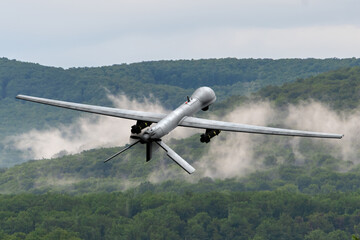 Modern technology in action - reconnaissance drone in the air. Heavy UAV with weapons in flight,...