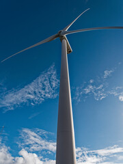 Wind turbine, view up tower to nacelle with rotor blades and hub.