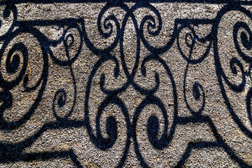 Shadow Wrought iron bridge railing on a sunny winter day with blue sky