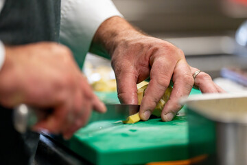 Cuisinier professionnel en pleine préparation culinaire.