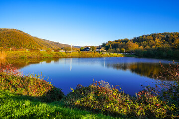 View of the Eiserbachsee lake in Rurberg near Simmerath. Landscape at the Eiserbach dam. Nature in the Eifel region.
