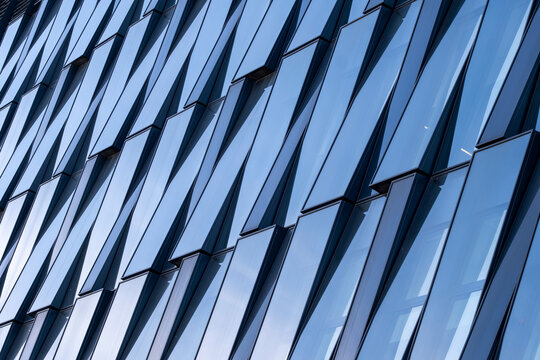 Glass facade with abstract reflections, repetitive patterns, geometric lines and shapes, modern architecture, urban design details.
