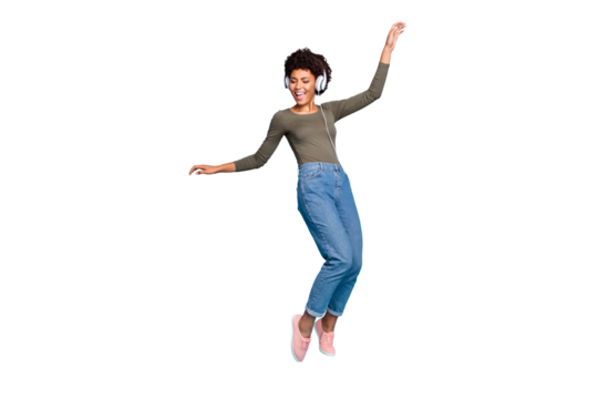 Full body photo of cheerful funny mulatto girl have free time listen music on her headset dance sing enjoy wear stylish green pullover denim jeans sneakers isolated over blue color background
