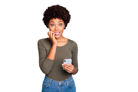 Omg blog troubles. Portrait of negative afraid mulatto girl feel nervous bite nails use cellphone get notification about dislike wear green stylish pullover isolated over blue color background