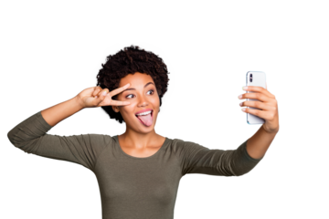 Photo of cute cheerful nice attractive black skinned woman fooling before camera showing v-sign sticking out wearing green sweater isolated over vibrant blue color background