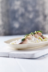 Herring in Cream Sauce on bright background. Copy space.	