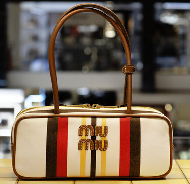Beau summer bag ,red-black stripe motif.Brown leather Miu miu logo.Milan - Italy,21 May 2025