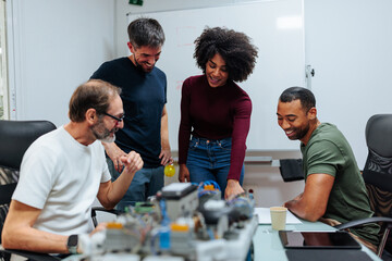 Engineers team analyzing electronic device in meeting room