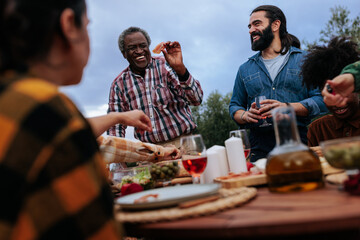 Happy family enjoying outdoor meal together: sharing laughter and food in nature