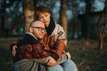 A couple shares a heartfelt embrace in an outdoor setting during sunset, showcasing love, warmth,...