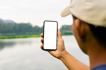 Man holding mobile phone with blank white desktop screen in the outdoor