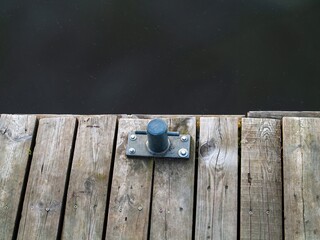Metal object is sitting on a wooden dock. Zagrze lake, Poland