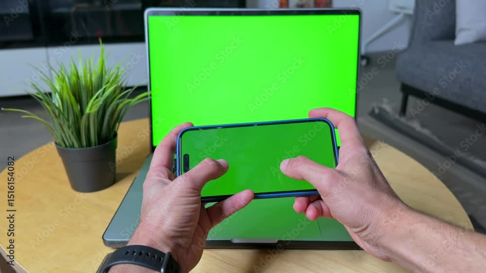 Aufkleber hands holding smartphone with green screen in front of a laptop with matching green screen. ideal fo