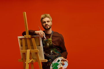 Handsome young artist creating a masterpiece in a vibrant studio setting