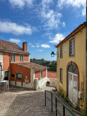 A colourful street scene in Sintra, Portugal, with traditional tiled buildings, terracotta...
