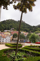 Obraz premium A colourful street scene in Sintra, Portugal, with traditional tiled buildings, terracotta rooftops, blooming flowers, and cobbled paths — the charm of old-world Europe.