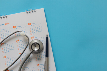 close up top view on stethoscope on calendar with over blue background for design about ads or...