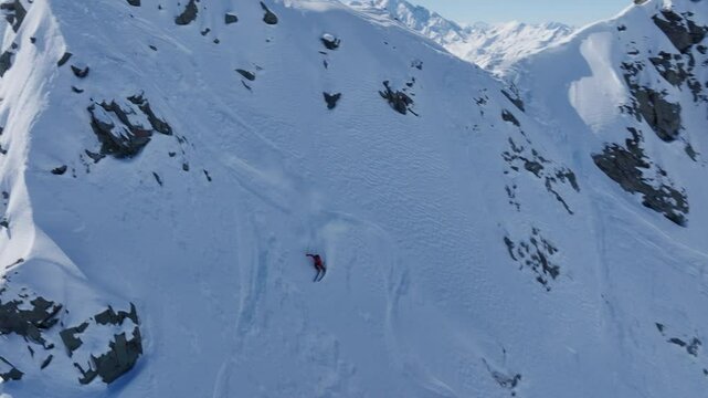 A professional skier hikes up a steep ridge in Verbier, then drops into an epic freeride descent. Pure adventure skiing in deep snow, dramatic terrain, and breathtaking alpine scenery.