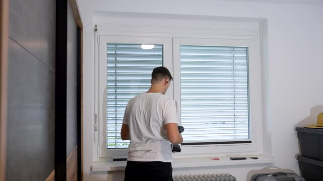 Man installing pleated blind on bedroom window. Time lapse shot.