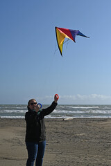 young woman playing with a kite against blue sky