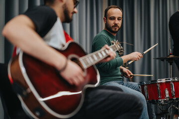 Musicians collaborating and playing instruments in a studio setting, expressing creativity and...
