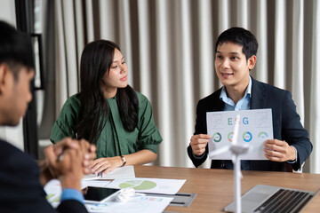 ESG Discussion in Business Meeting. Team member presenting sustainability metrics.