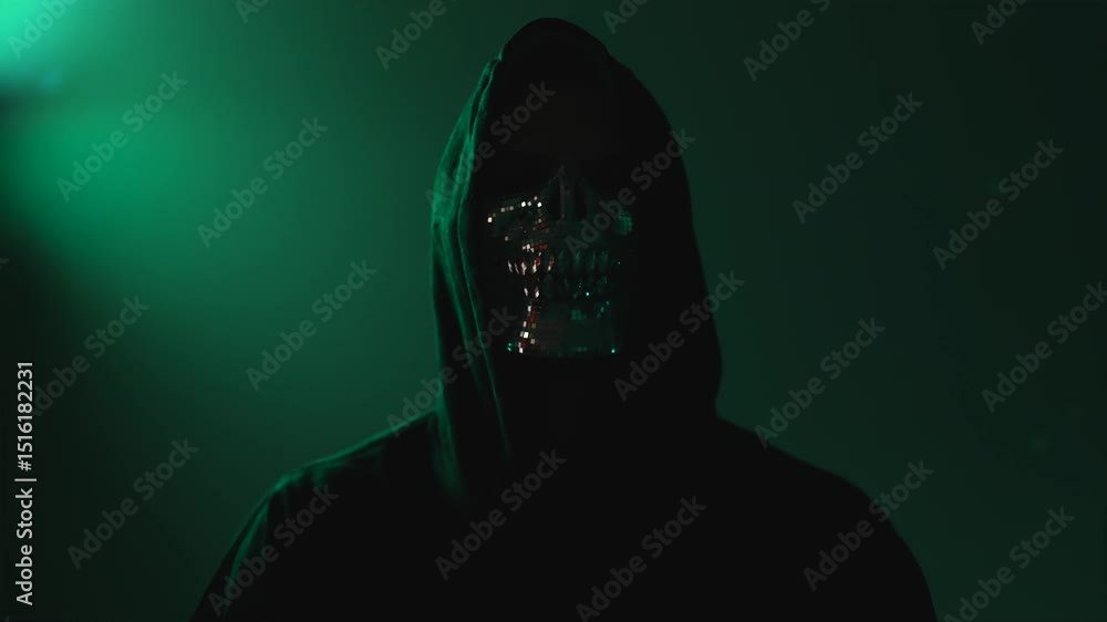 Poster anonymous hacker in hood and mask with crossed arms looking directly at camera – represents malware,