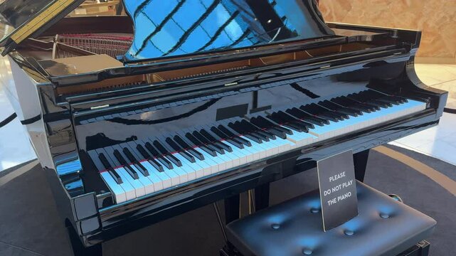 Self-playing grand piano, with sign saying 'Please do not play the piano'.