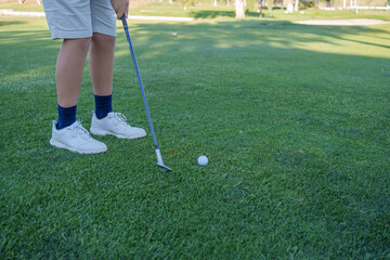 Golfer preparing to hit ball on lush green course