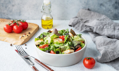 Vegetarian salad with lettuce, tomatoes, croutons, olives and parmesan cheese  in a bowl