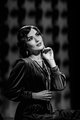 Black and white portrait of attractive glamorous young actress posing in vintage clothes. Elegant...