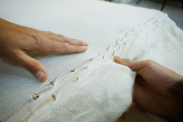 Close up of craftswoman fastening carpet base on frame