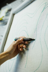 Cropped shot of craftswoman drawing on carpet embroidery base