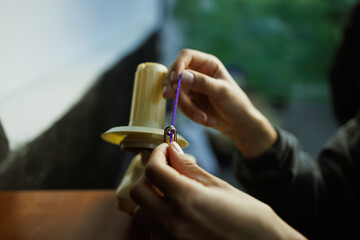 Obraz premium Cropped shot of craftswoman rolling acrylic thread on ball winder