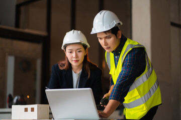 Engineer teams meeting working together wear worker helmets hardhat on construction site. Asian industry professional team.
