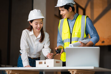 Engineer teams meeting working together wear worker helmets hardhat on construction site. Asian industry professional team.