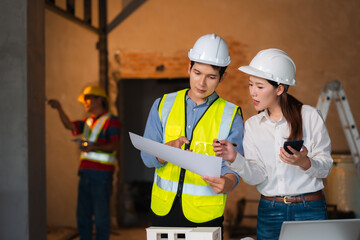 Engineer teams meeting working together wear worker helmets hardhat on construction site. Asian industry professional team.