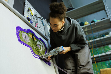 African american craftswoman making rug with rug tufting gun