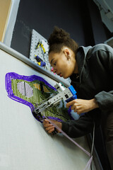 African american craftswoman making colorful rug in workshop