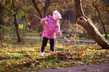 Child Raking Autumn Leaves in a Colorful Garden