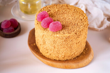 Delicious homemade cake with honey on a pink background. A birthday cake. Sweet dessert. Close-up