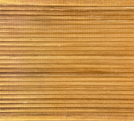 Close up of natural brown wood decking with grouts, suitable for outdoor deck and cladding. Solid brown wooden deck with fluted panel and horizontal stripes. Seamless background texture