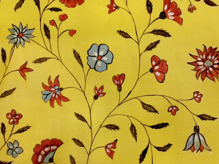 Close up of red and blue flower illustration painted and printed on a yellow background. Floral...