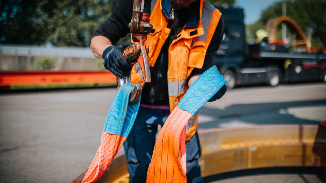 Worker with Sling Rope Preparing for Heavy Lifting