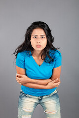 A young woman confidently poses wearing blue t-shirt, distressed denim jeans, heels, showcasing a casual urban style with charm and elegance, suitable for haircare, freedom, self-expression project